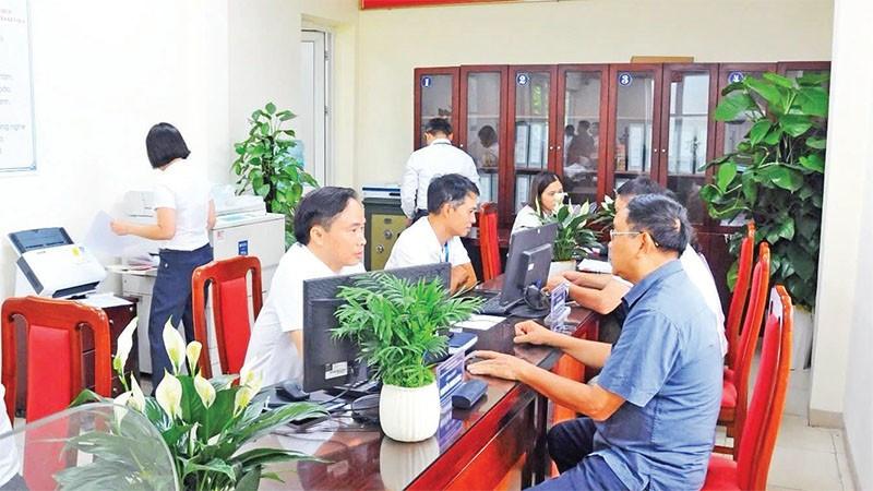 Người dân đến làm thủ tục hành chính tại phường Long Biên (mới) ở Hà Nội. (Ảnh QUỐC TOẢN)